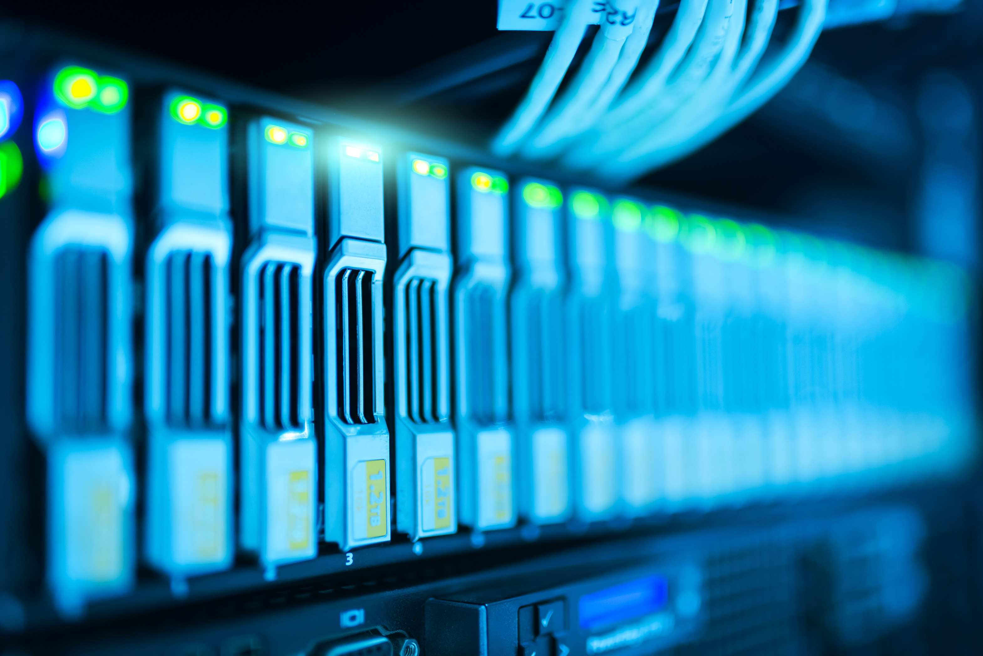 Wide view of a server room with racks and cabling, server rack with glowing lights in a modern data center